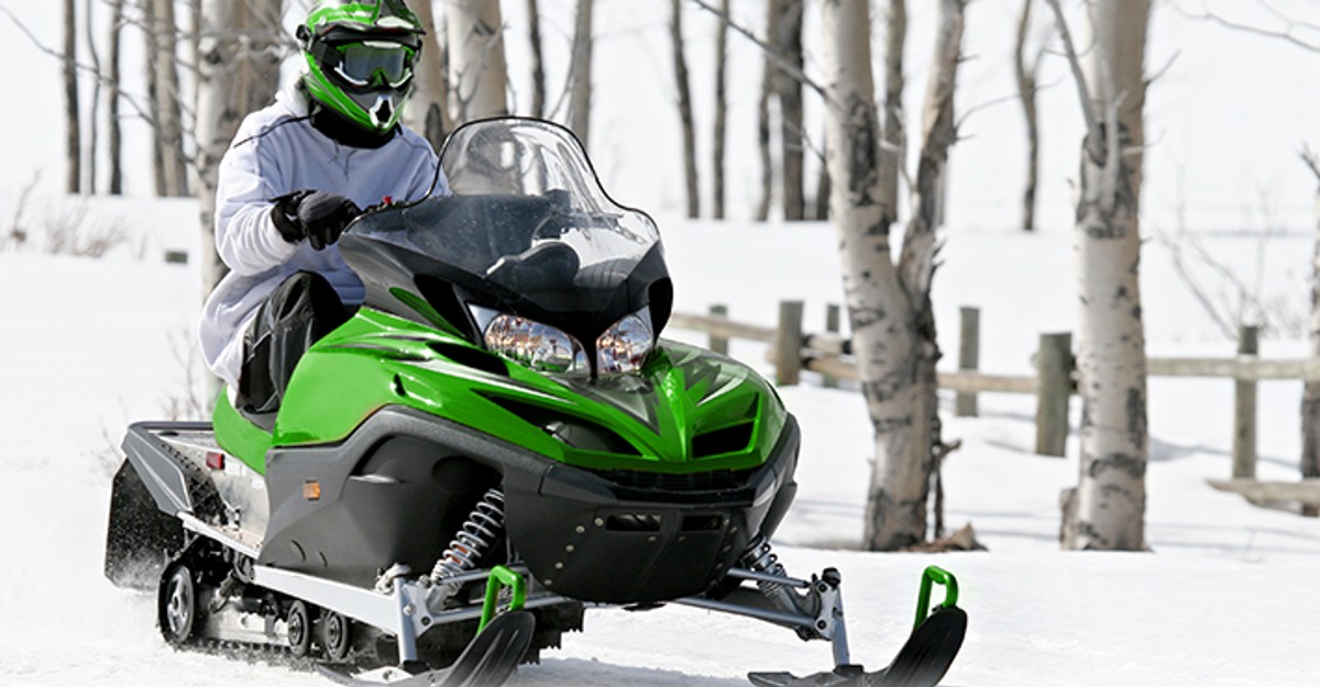 Man on a Green and Black Snow Mobile